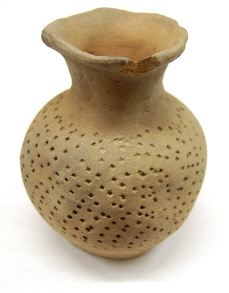 light brown pottery vase with circular perforation design