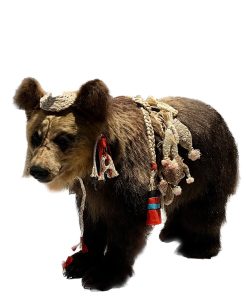 stuffed bear cub decorated with woven belts and earrings