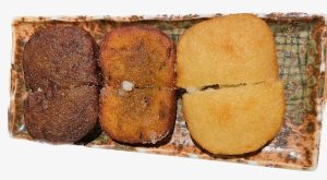 three ainu potato dumplings arranged vertically on plate