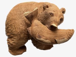 wood carving of bear holding salmon in its mouth