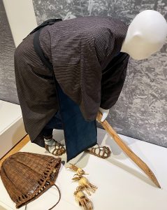 mannequin model of Ainu woman gathering roots with a stick
