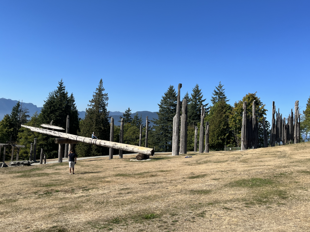 Sculpture made of several large cedar poles located on hillside