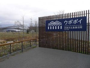 Entrance gate to park area with large museum building in background.