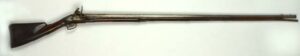 Photograph of Flintlock fowling piece,1750–1770. Wood, iron, brass, and flint fowling piece; part round, part octagon barrel with bayonet lug at bottom of muzzle and bladed brass front sight; brass furniture; brown musket flint and wooden ramrod with iron worm at tip; relief carving around barrel tang, trigger guard, and on forestock underside; stamped marks near breech end of barrel; incised lettering on buttstock.