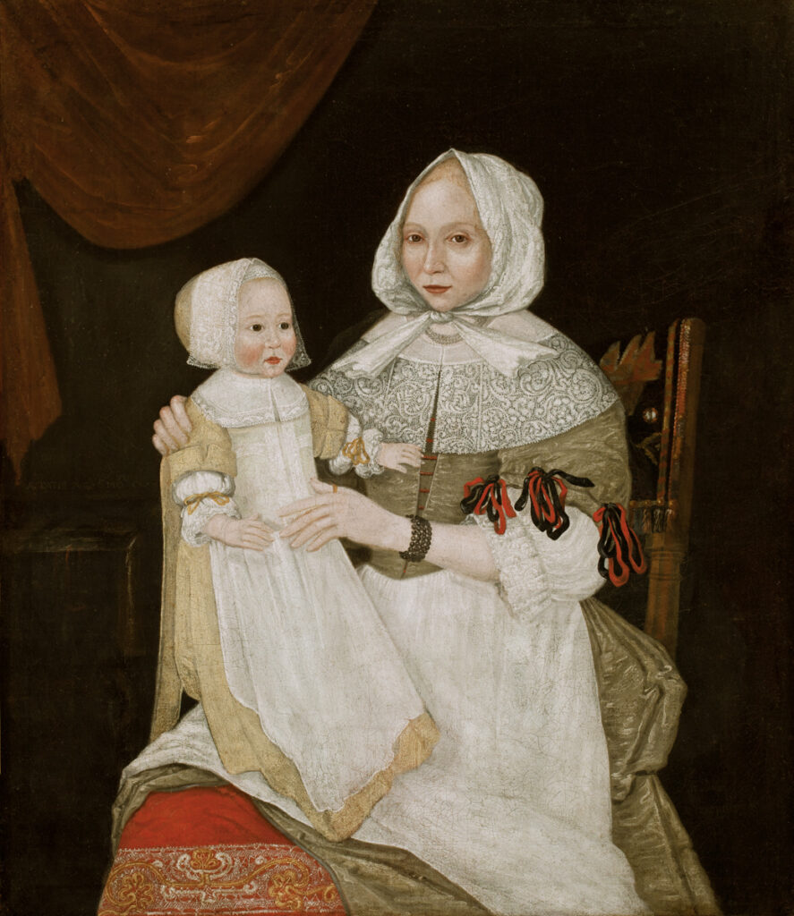 A double portrait of a woman holding an infant upright on her lap. The woman is represented in three-quarter length and turned to the viewer's left. She sits upright with her proper left hand crossing her body and resting on the infant's belly. Her right hand holds the child's proper right shoulder. The woman wears a white cap on her head that forms a peak over the forehead and is tied in a knot below the chin. Two fanlike ends of the cloth stiffly splay from the knot to her shoulders. The woman has light brown eyes and reddish blonde hair that is visible at the forehead and along the edges of the cap. Her complexion is a pale pink, lighter than the skin in the companion portrait, John Freake. The face is an oval with a small, rounded chin.