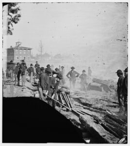 Union soldiers destroy a section of railroad in Atlanta, Georgia, to prevent the Confederacy from receiving iron shipments. Photograph by George N. Barnard, 1864.