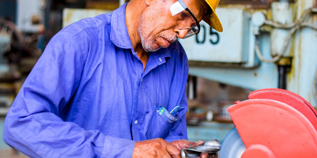 Focused tradesperson grinding metal, showing the commitment and dedication needed in the trades