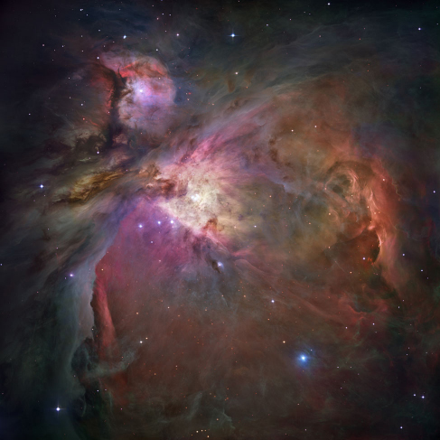 Photograph of the Orion Nebula. This image is dominated by large areas and bright swirls of glowing gas clouds, crisscrossed by dark bands of dust.