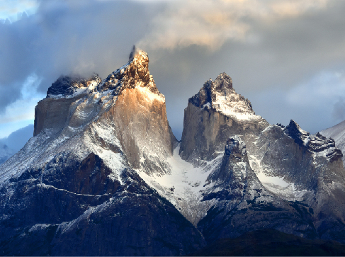 Image of the Torres del Paine mountains in Patagonia. The peaks of the mountains are sharp and jagged.