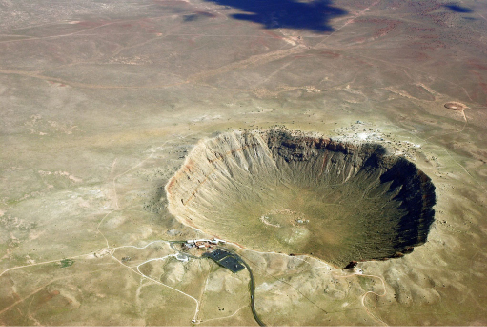 Aerial photograph of Meteor Crater in Northern Arizona, a nearly perfect bowl-shaped excavation in the flat desert landscape.