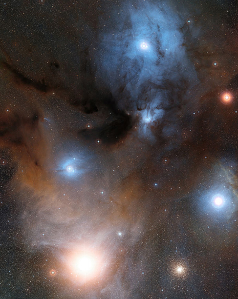Various Types of Interstellar Matter. Antares, the brightest star in the constellation Scorpio, is at lower left in this wide-field image. It is surrounded by reddish nebulosity. To the right of Antares is the globular cluster M4. At center left a bright star is surrounded by the blue glow of a reflection nebula, and at center right another bright star is surrounded by red nebulosity. Above these two stars a dark nebula snakes its way across the image, blocking the light from behind. Finally, at top center, a bright star is surrounded by a large area of blue reflection nebulosity, criss-crossed by dark dust lanes.