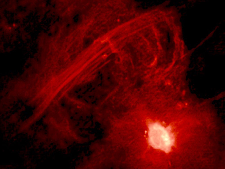 Central 10 Light-Years of the Galaxy. The bright region at lower right is Sagittarius A* and the straight filaments running from lower left to upper right are collectively known as “The Arc”. See [Figure 25_04_RImage] to see these features in context with other objects near the galactic center.