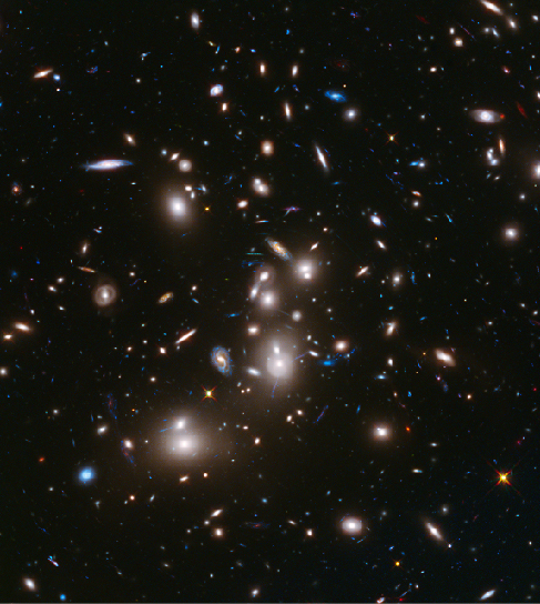 Image of galaxy cluster Abell 2744. Several large, bright elliptical galaxies dominate this cluster of galaxies, which is massive enough to act as a gravitational lens to brighten and magnify the images of nearly 3000 distant background galaxies.