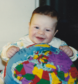 Photograph of an infant human, playing with a toy globe of the Earth.