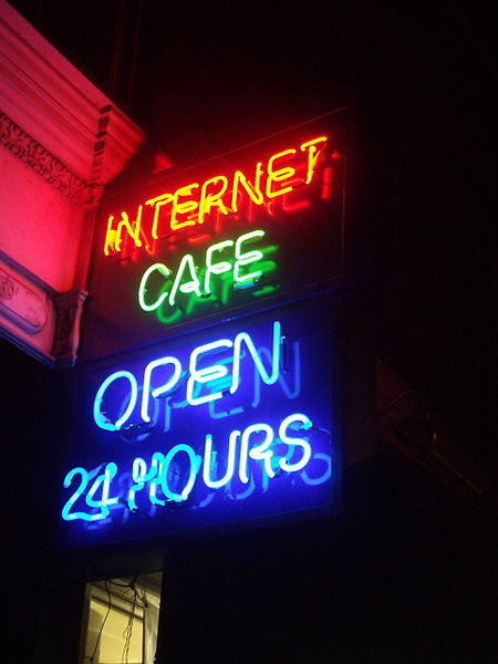 The different colors of these “neon” lights are caused by gases other than neon in the discharge tubes. Source: “Neon Internet Cafe open 24 hours” by JustinC is licensed under the Creative Commons Attribution- Share Alike 2.0 Generic license.