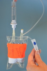 Lower secondary IV bag below primary and open clamp to flush out secondary IV line