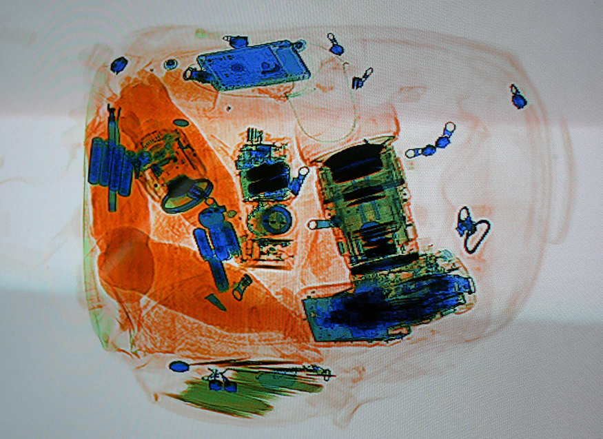A colored X-ray image of a piece of luggage.