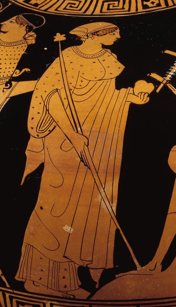 A red-figure depiction ofAphrodite, robed and in a head scarf, holding a staff in one hand and an apple in the other.