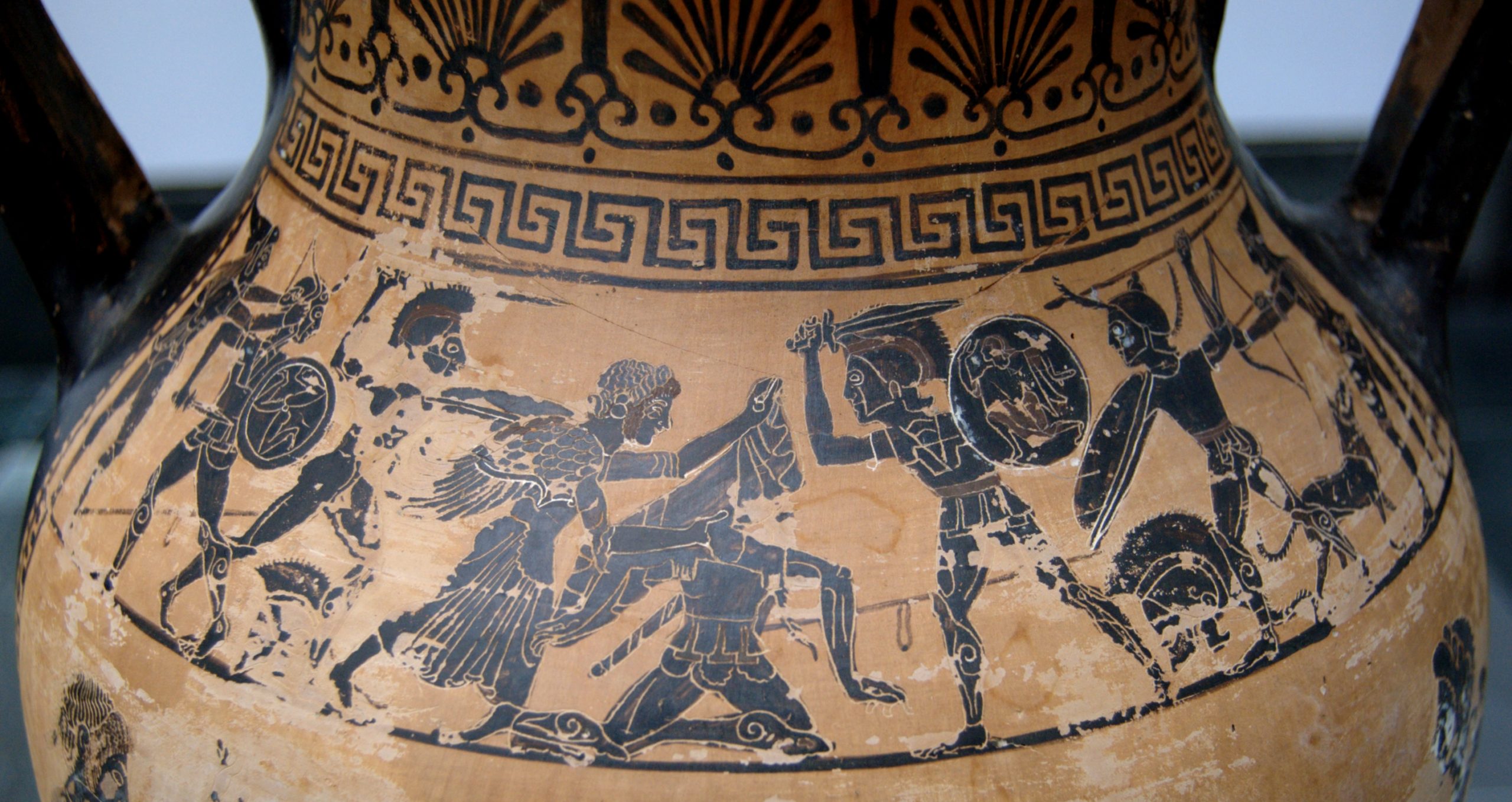 The belly of a black-figure amphora depicting Aphrodite at Aeneas&#039; side as warriors with swords and shields press in from either side.