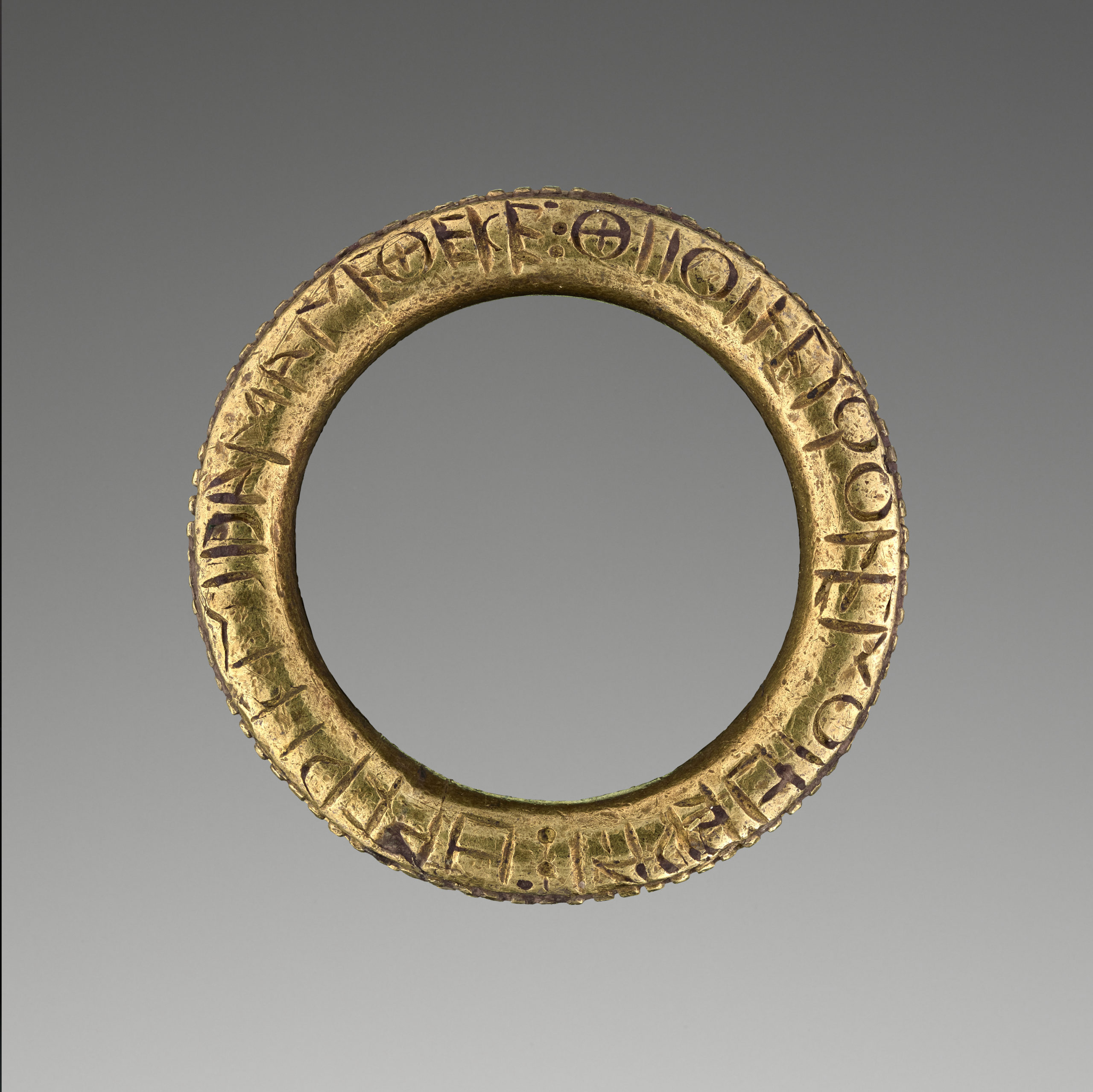 A gold ring with an inscription in Greek.