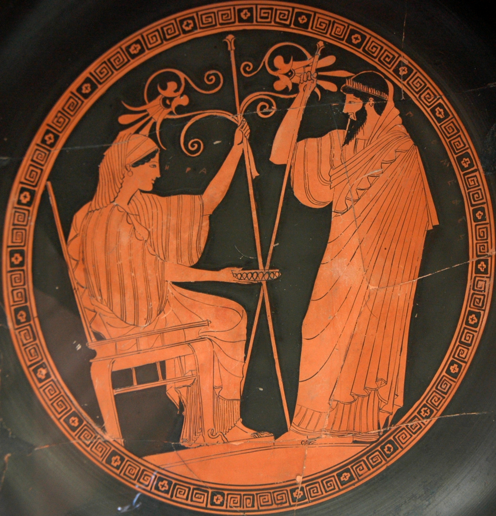 Throned and robed Hera, holding a tall scepter, sits before Prometheus