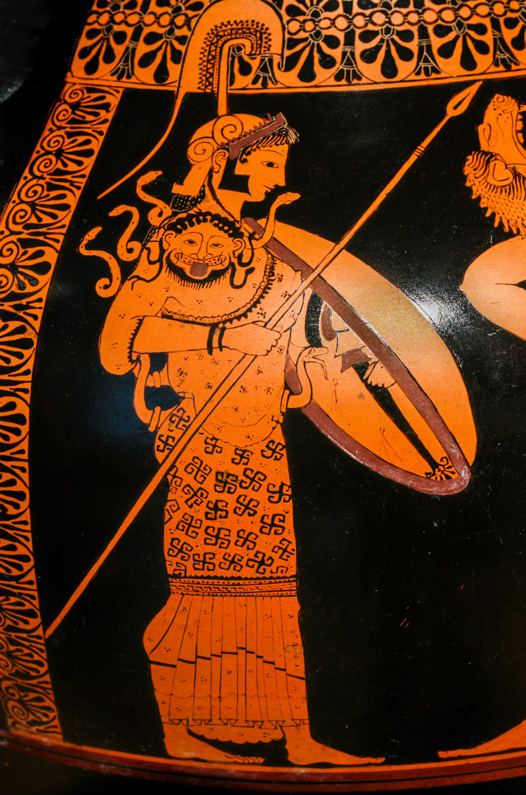 Athena stands holding a spear and shield. She is wearing a helm and the aegis, with the head of Medusa clearly visible on it.