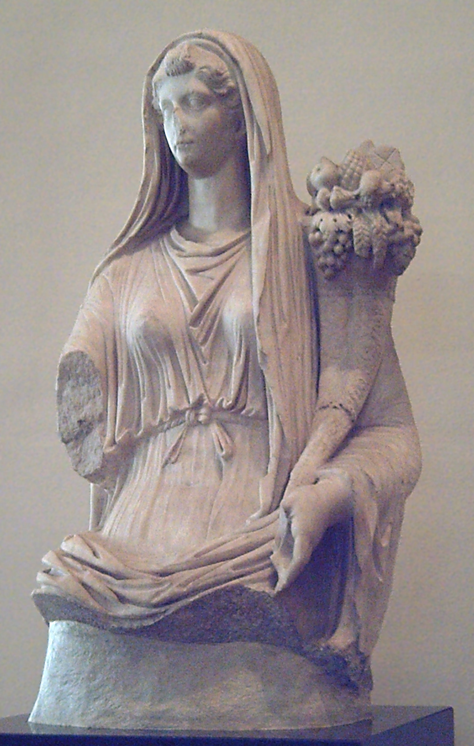 Head and torso of Livia Drusilla. She is veiled and robed, and holding a cornucopia.