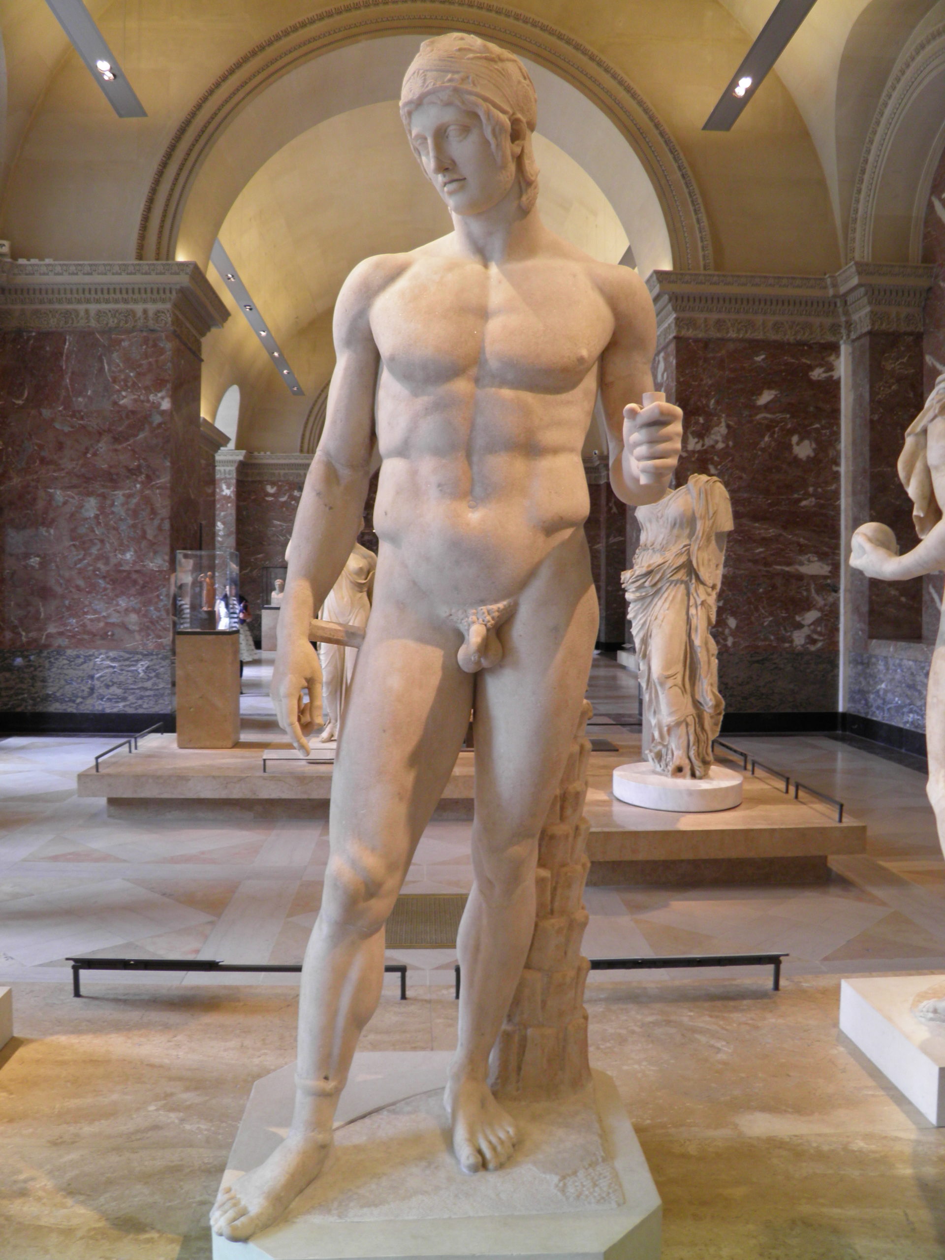 Mars standing in the nude. He is wearing a helmet, and on his right ankle is an ankle bracelet.