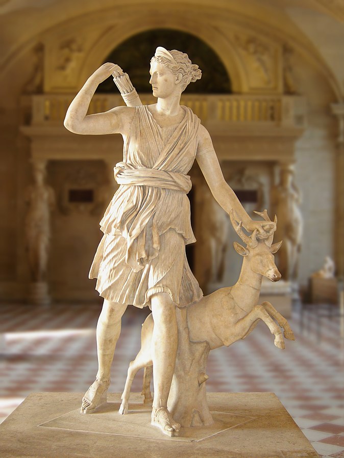 Diana as a young woman with a tunic and sandals. She is running next to a small deer, and one of her hands reaches for an arrow from the quiver on her back.