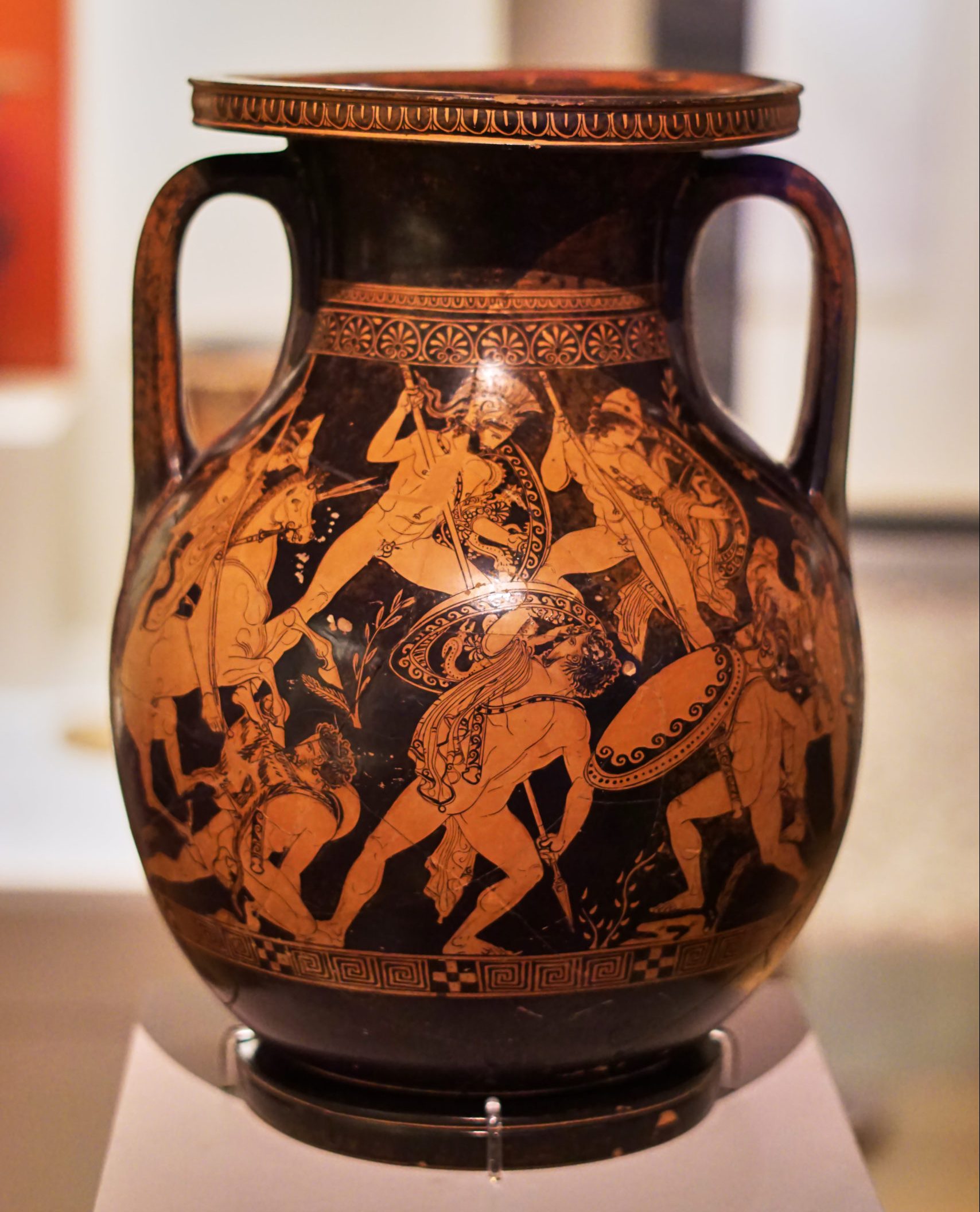 Ares and two other gods (the Dioscuri) leap down from above and attack a group of giants. Ares, in a plumed helm and carrying a shield, stabs a spear into the giant below.