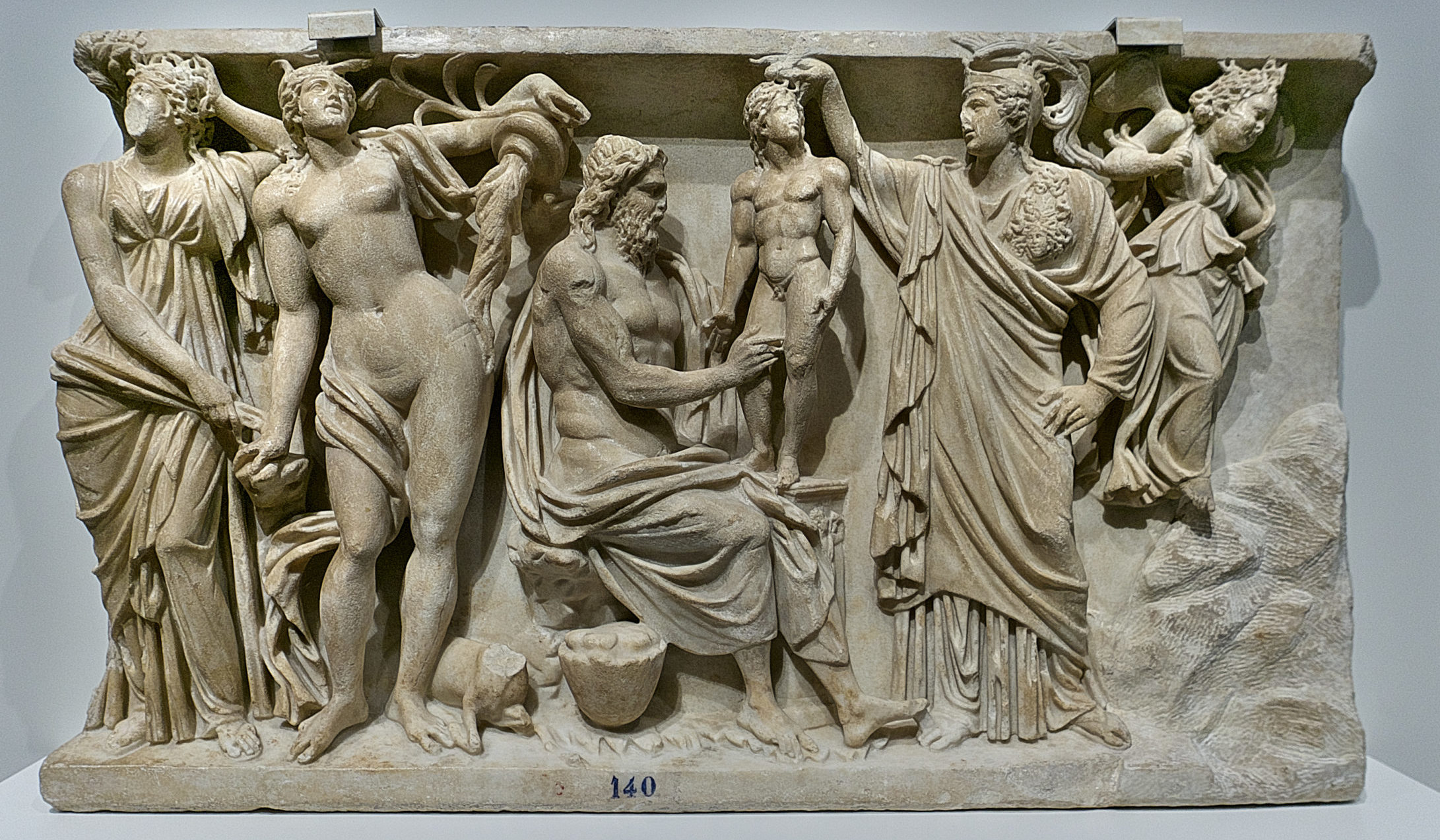 Prometheus sits with a small figure of a man on his lap. Athena stands in front of him, her hand on the head of the small man. Various other deity figures stand by.