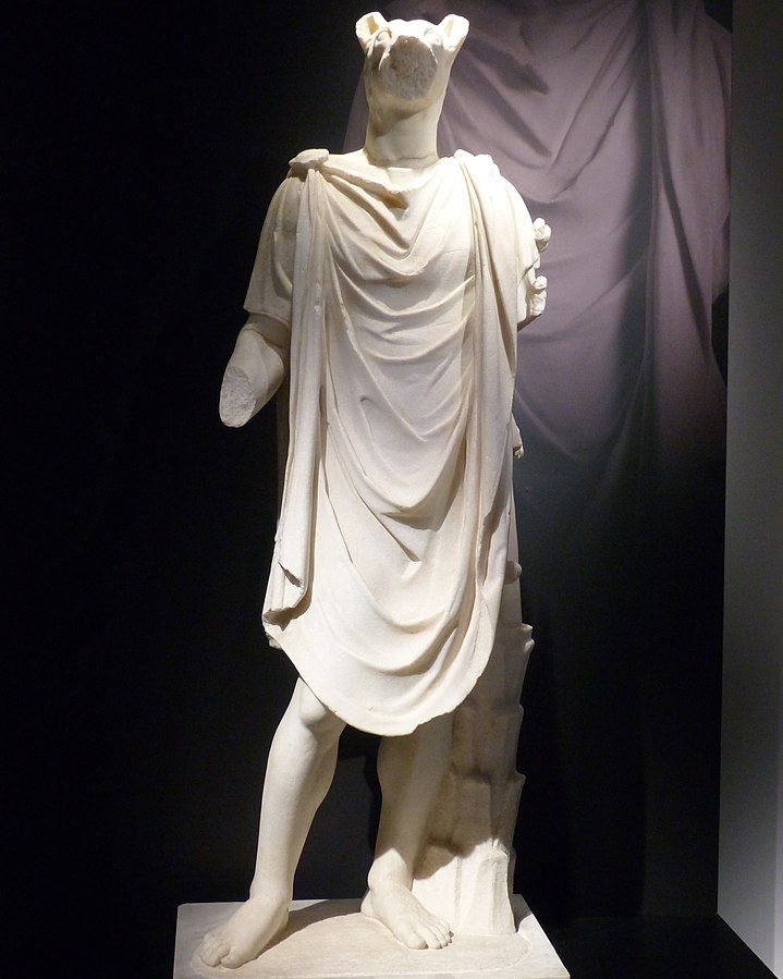 Hermanubis, a person with the head of a jackal, wearing a chlamys. The arms of the statue are missing.