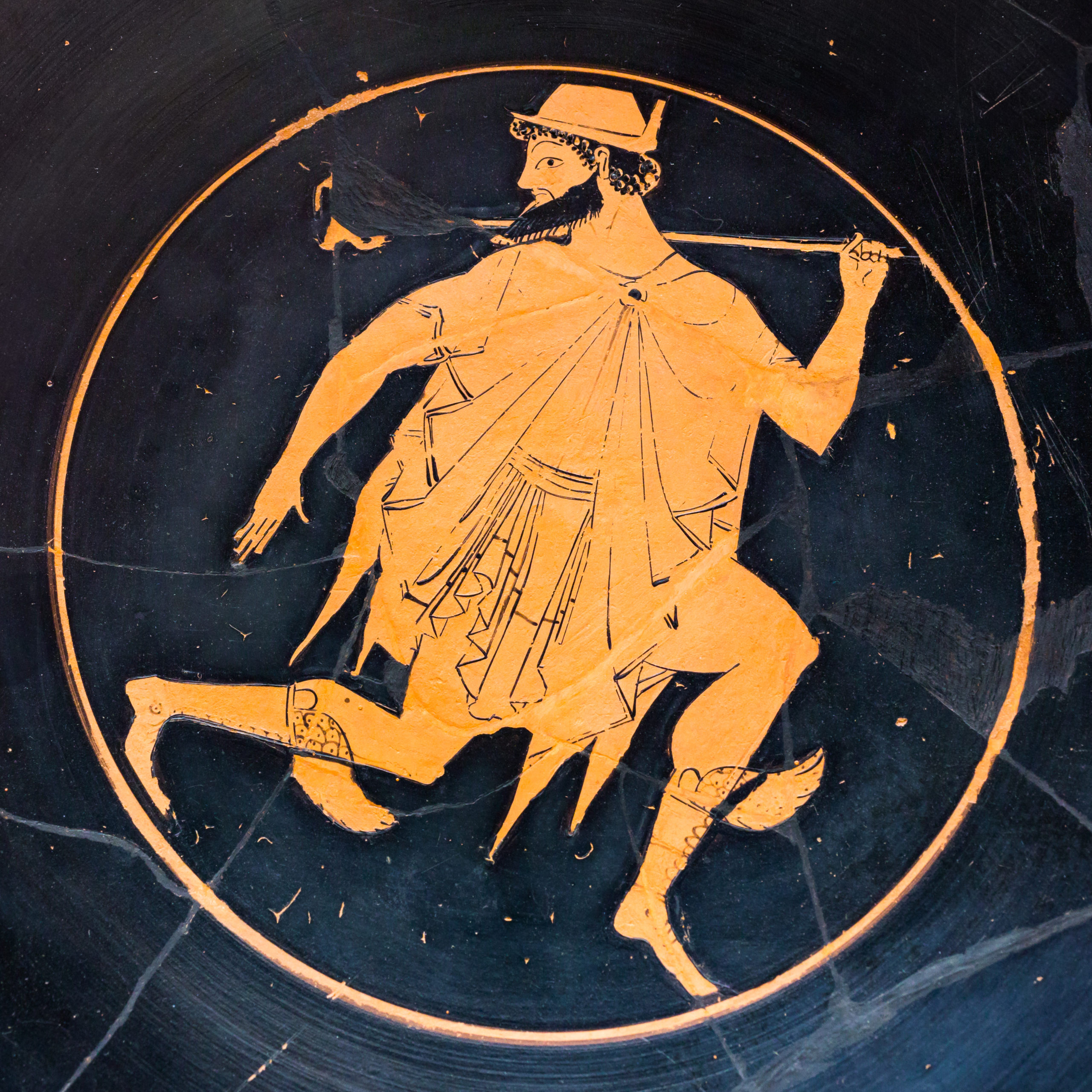Hermes running. He is a bearded man wearing a chlamys cloak, petasos hat, and winged boots. He holds a scepter over one shoulder.