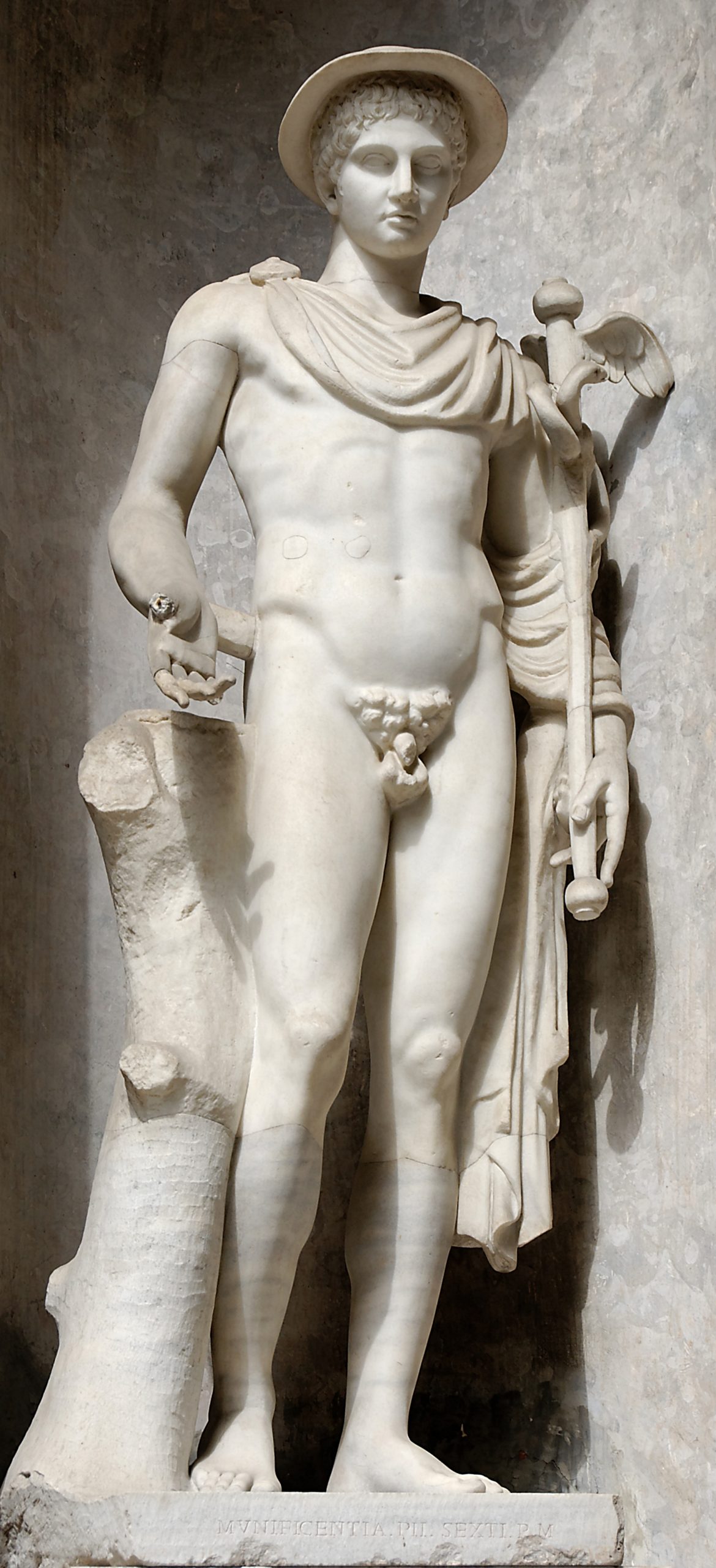 Hermes as a young man. He is naked except for a chlamys cloak draped over his left shoulder, and a petasos hat. He holds a winged sceptre in his left hand.
