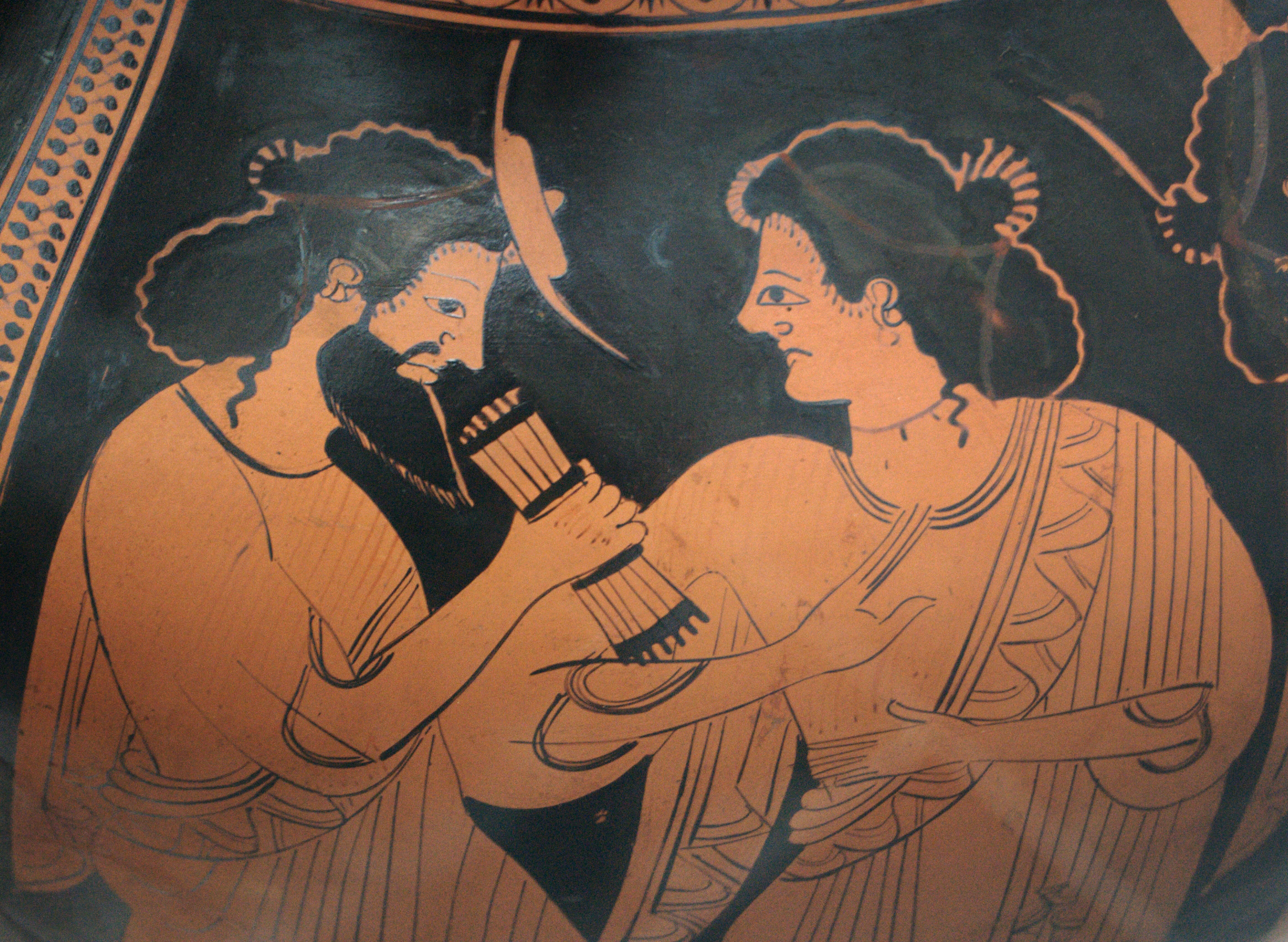 Bearded Hermes standing beside his mother Maia. Hermes holds a strange scroll or bundle of sticks in his hand.