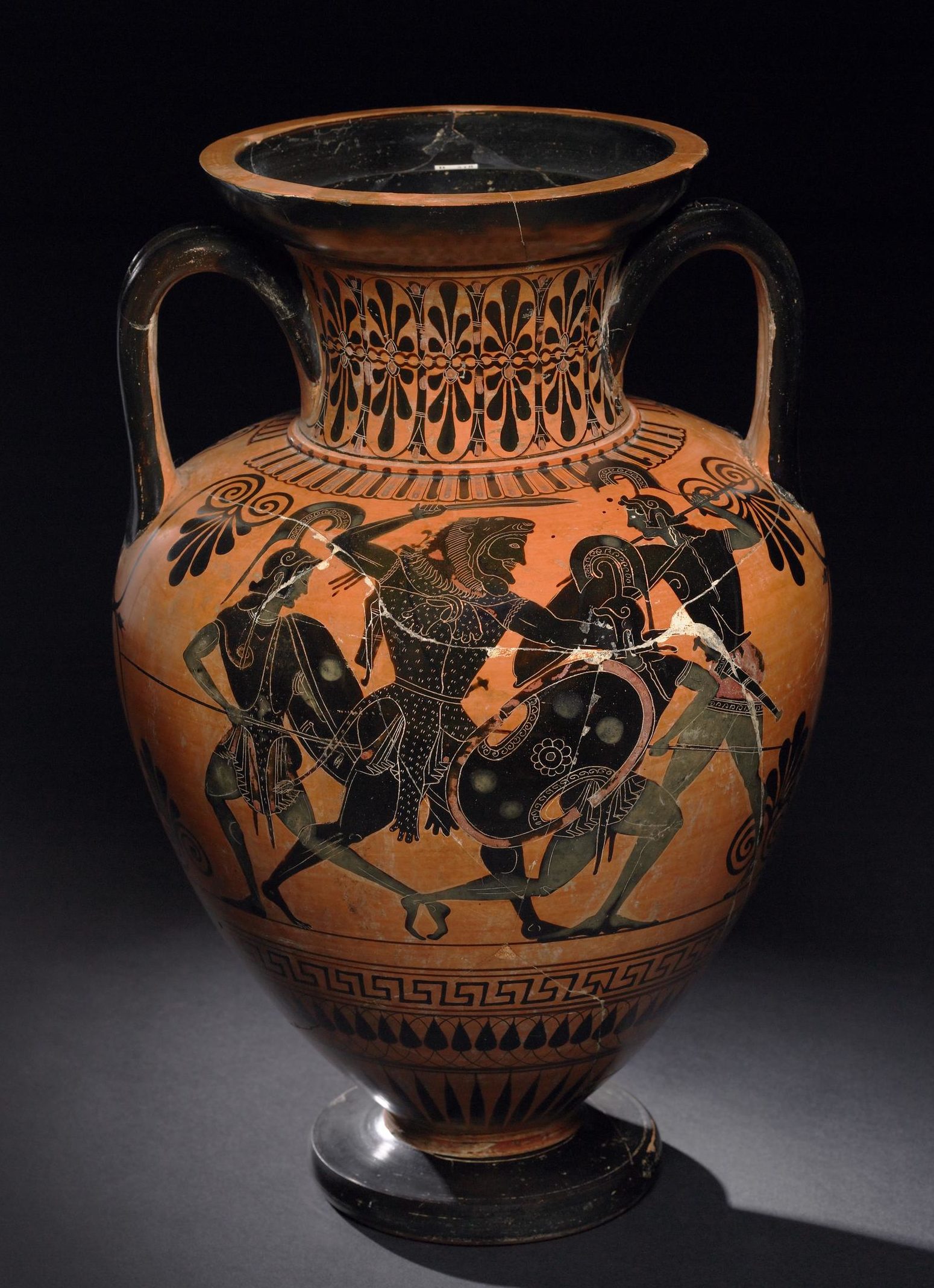 Heracles fighting 3 Amazons. He has his sword raised to strike on of them, who is on one knee, while the other two lunge in towards him with spears.