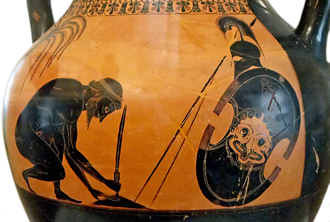 Ajax kneels holding his sword. His armour and shield are propped up beside him. His shield depicts the head of a grinning bearded gorgon with her tongue sticking out.