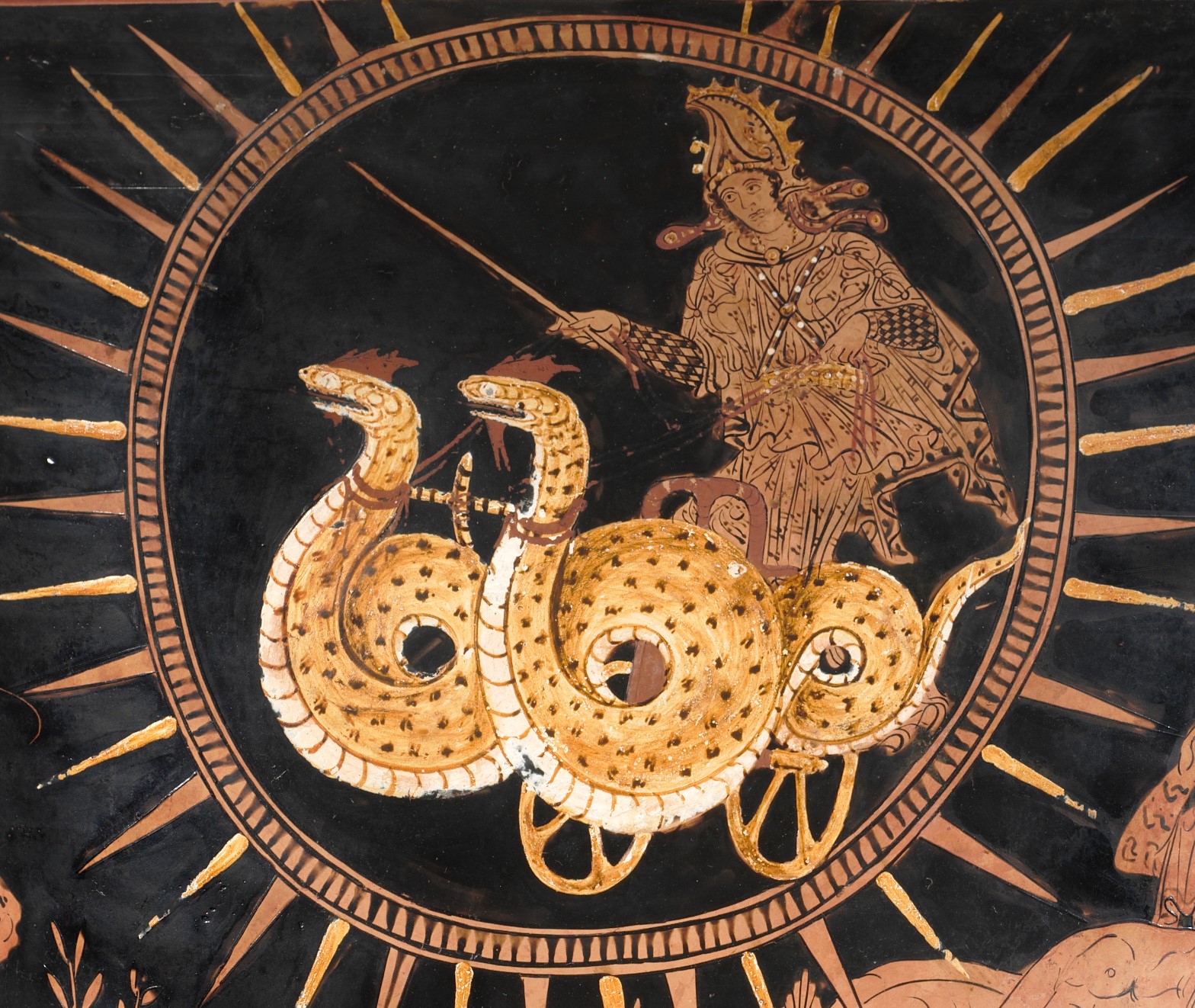 Inside a frame of sun rays, Medea rides in a chariot drawn by two serpentine dragons.