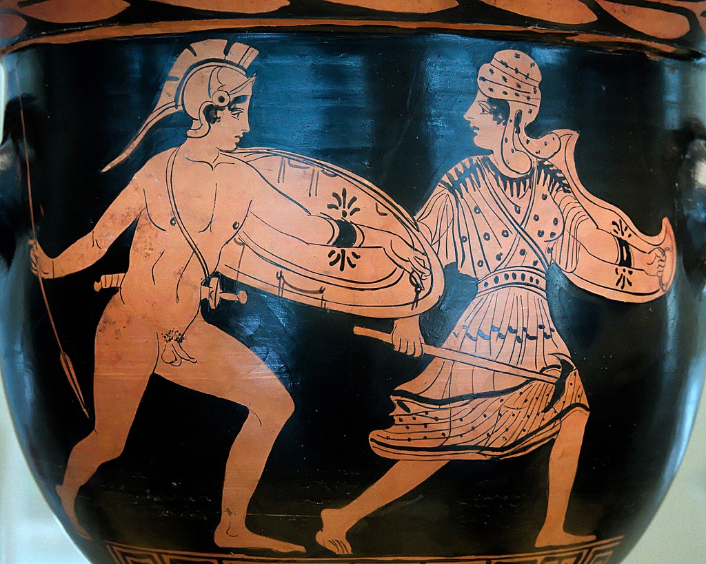 Achilles, nude with shield, helm, sword, and spear, pursues Penthesilea. Penthesilea wields a shield and axe and wears a tunic and wrapped headdress. She runs away, with her head turned back to look at Achilles.