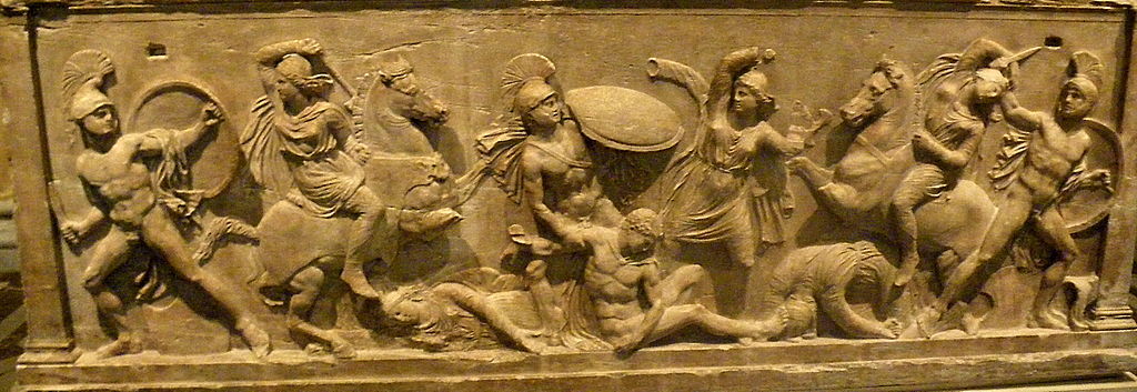 3 Amazons fight 3 Greek warriors, and three more Greek and Amazon figures lie wounded on the ground. The Greek warriors are nude with knives, shields, and helms. The Amazons wear tunics and wield axes, and two of them ride horses.