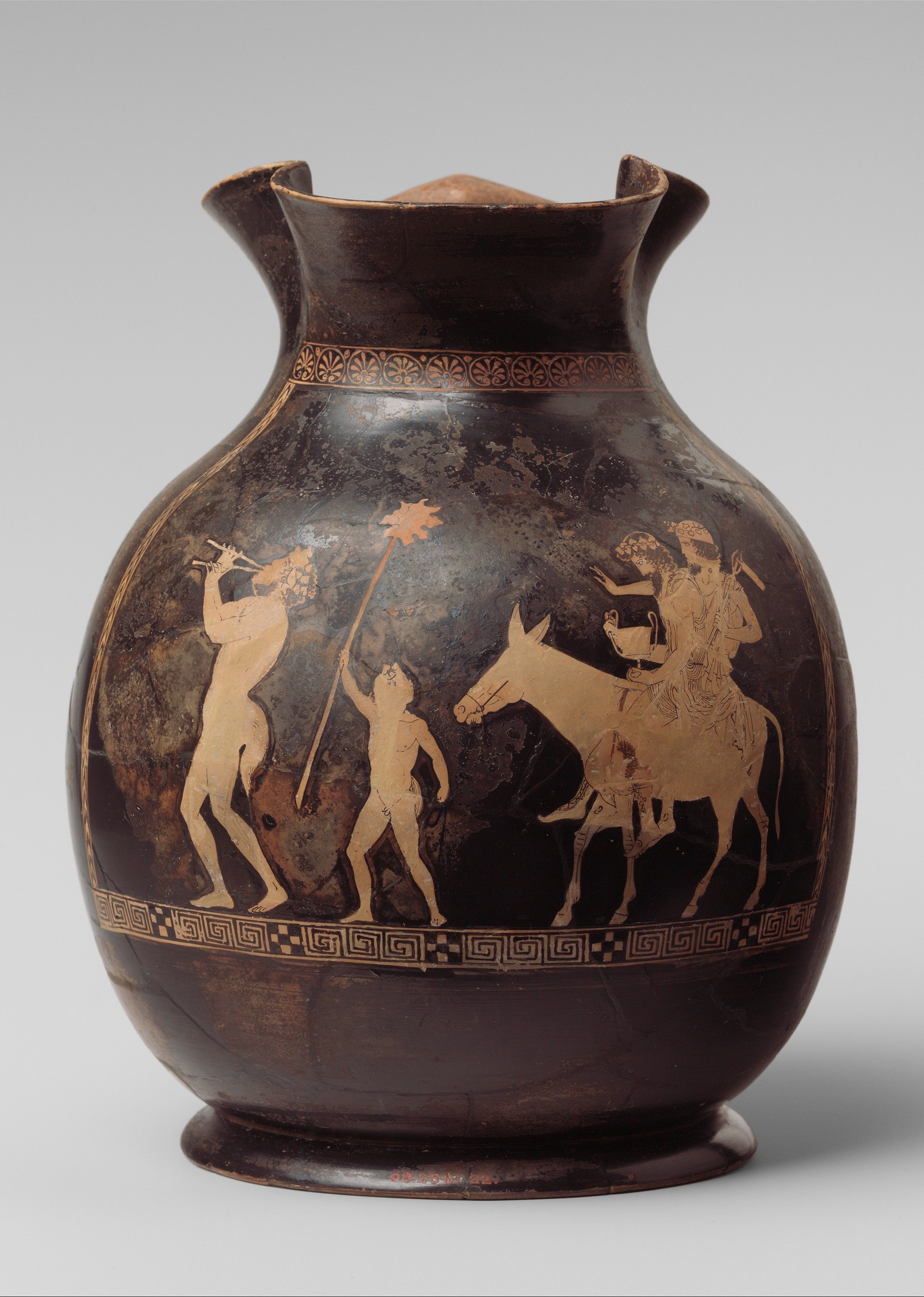 Hephaestus and Dionysus ride a donkey. A silenus playing a flute, and a small person holding a thyrsus, walk ahead.