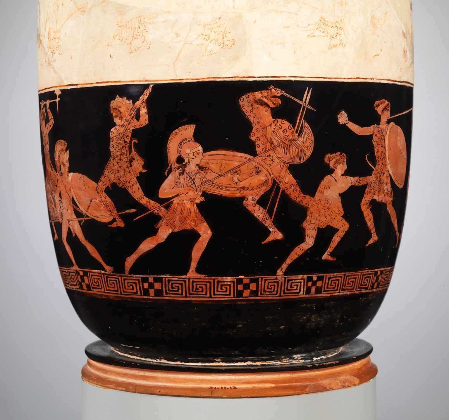 Two Greeks, with plumed helms, round shields, tunics, and spears, fight 4 Amazons. The amazons carry crescent-shaped shields and fight with swords, and are dressed in hats and patterned body suits.