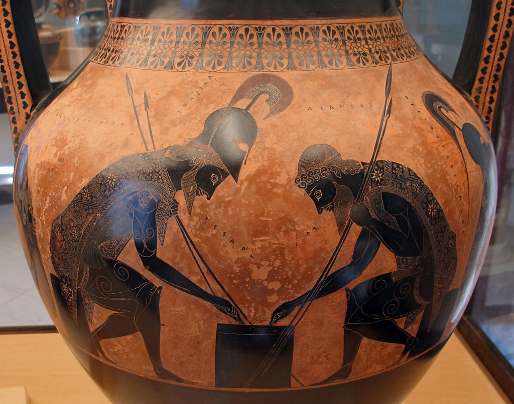 Achilles and Ajax sit across from each other a small table, playing a game. Both are bearded and carry spears and wear floral-patterned tunics and greaves. Achilles wears his helm, while Ajax wears a rounded cap.