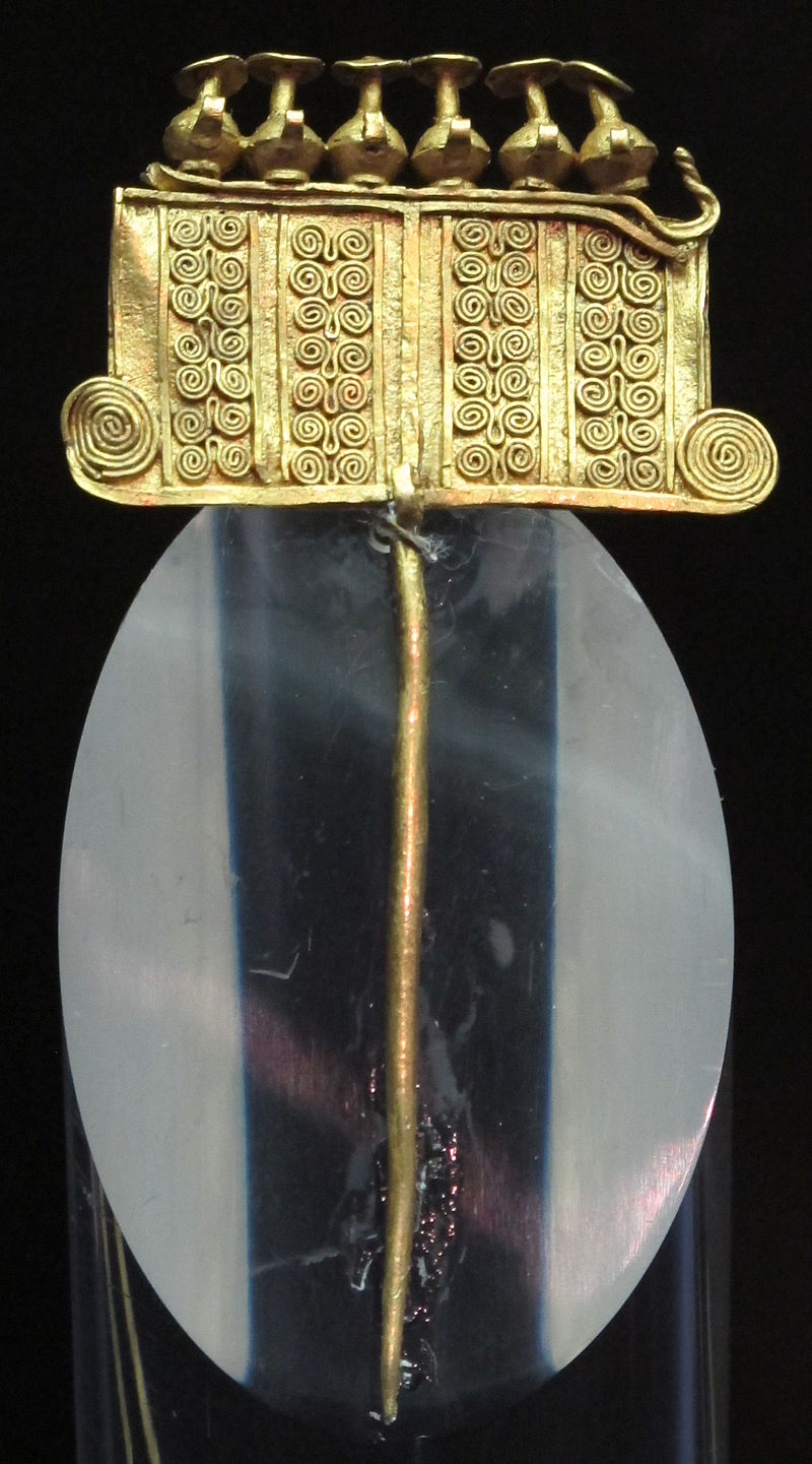 A gold brooch decorated with rows of tiny spirals.