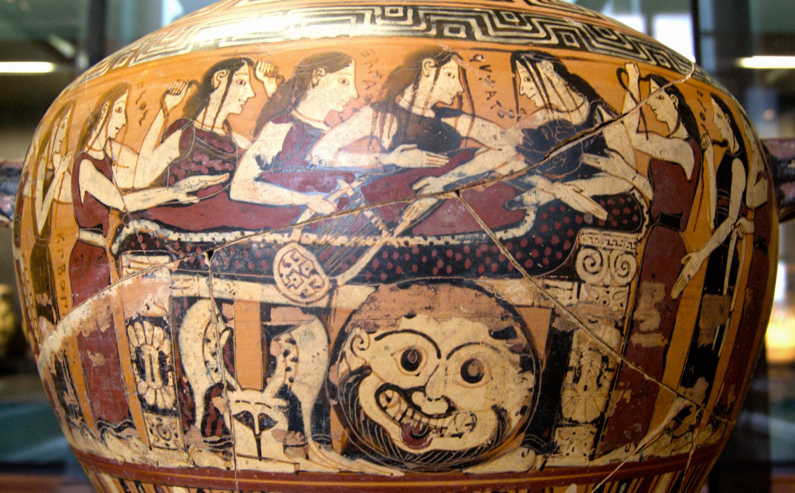 The body of Achilles, wrapped in a shroud, lies on a bench. Thesis, a woman with loose, messy hair, stands over him and clutches his body. A group of nereids, similar to Thetis in appearance, stand by, pulling their hair. A shield decorated with a Gorgoneion, along with a plumed helm, is propped up against the bench. Achilles is represented in black, while the women are painted in white.