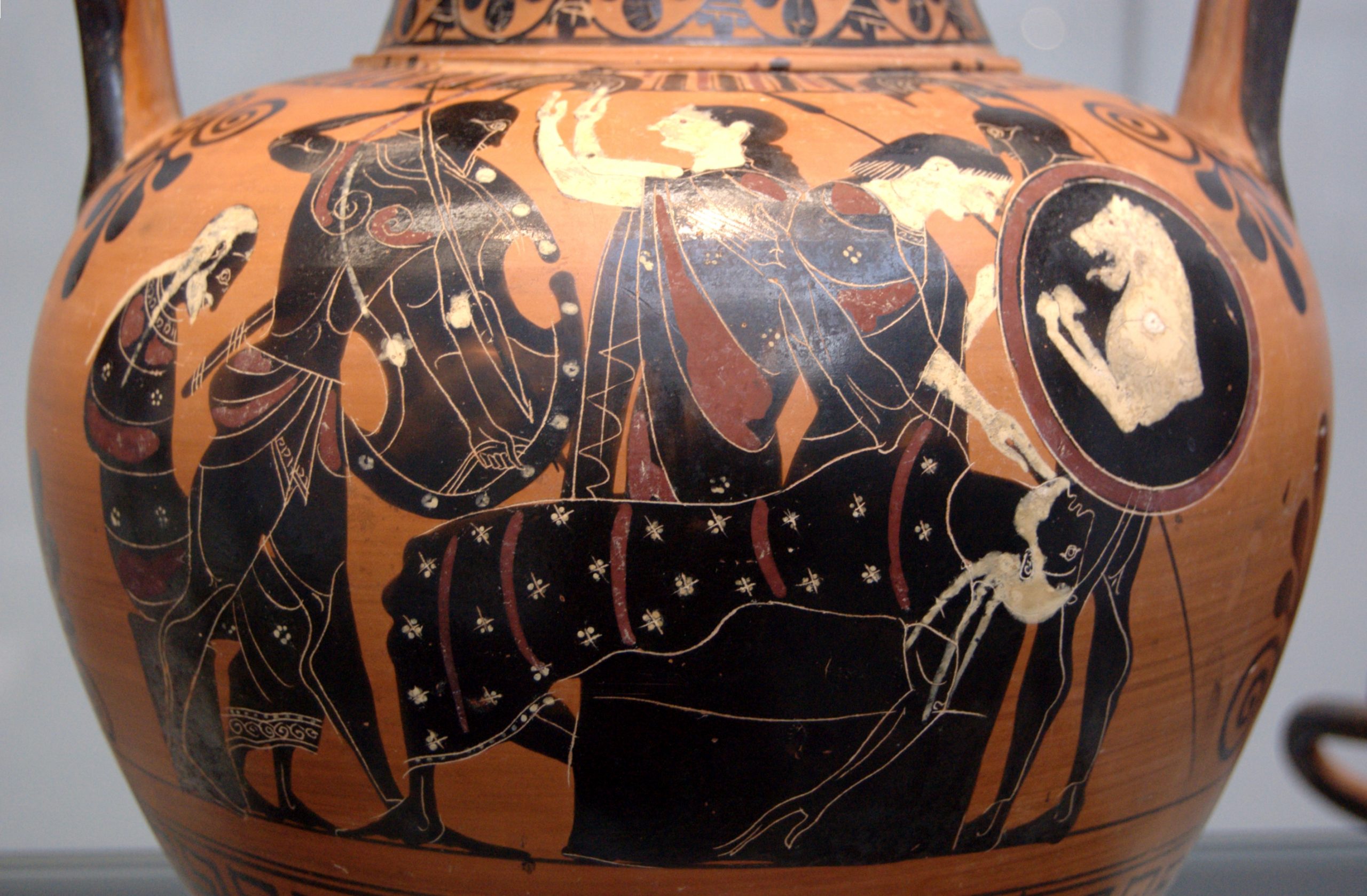 Priam, with white hair and beard and a patterned garment, lies on an altar. Neoptolemus, in Greek armour, stabs towards him with a speer. Other figures, two women and two men, watch.