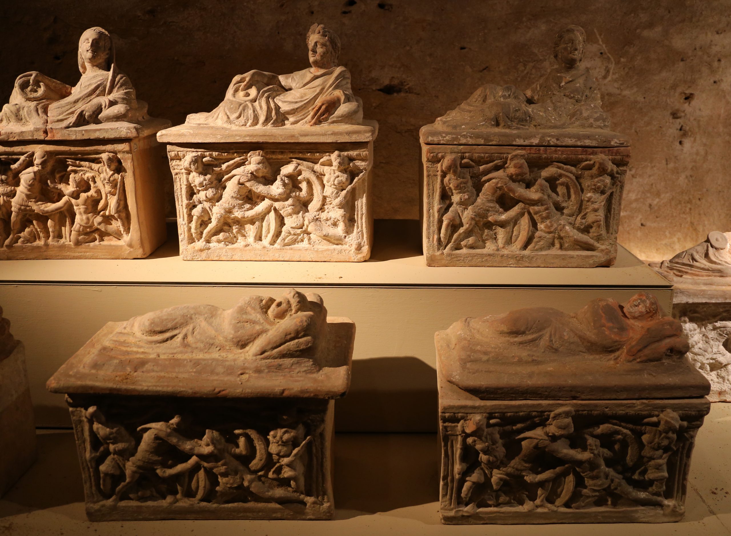 5 rectangular box-shaped funerary urns, each decorated on the side with near-identical reliefs of Eteocles and Polynices fighting. The lids of the earns are decorated with sculptures of the deceased reclining.