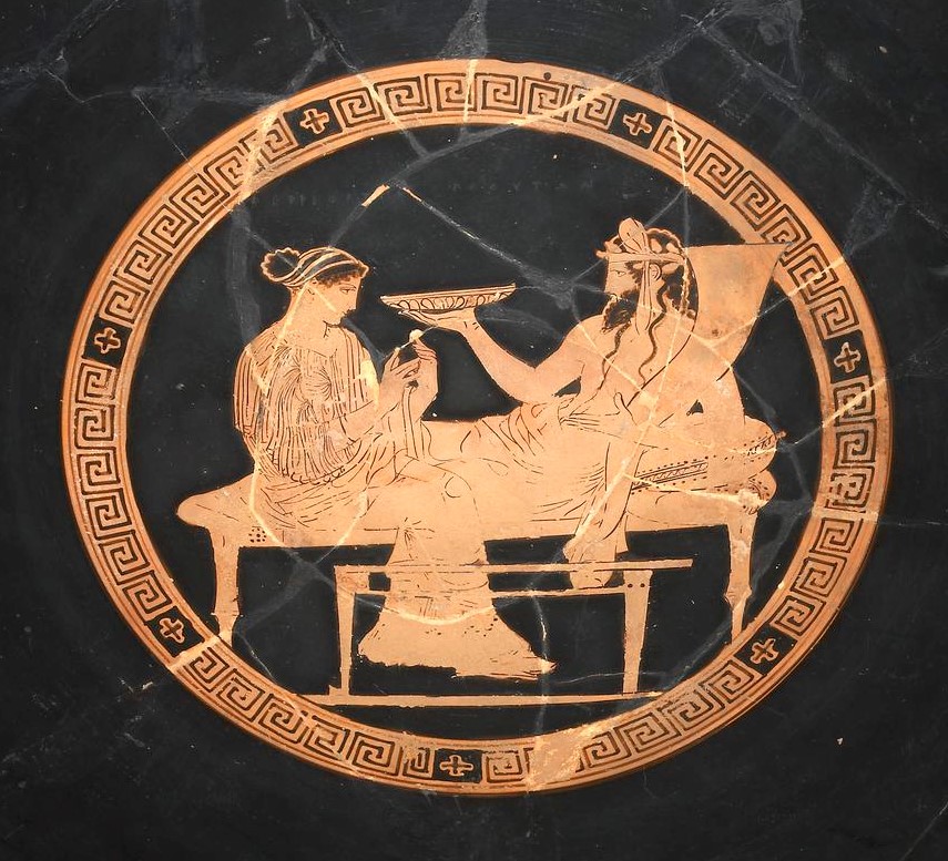 Persephone seated and Hades lounging holding a dish.