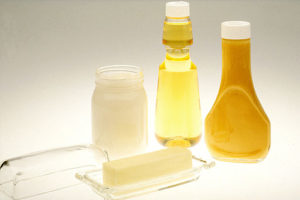Image shows a bar of butter, two bottles of cooking oil, and a jar of coconut oil.