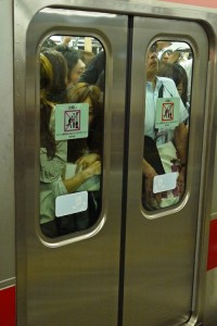 A train so full that people are pressed up against the doors.